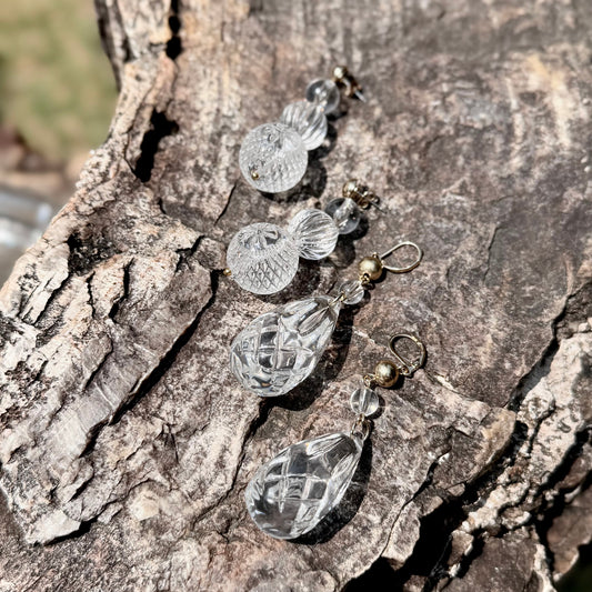 Crystal-like earrings on a textured stone surface