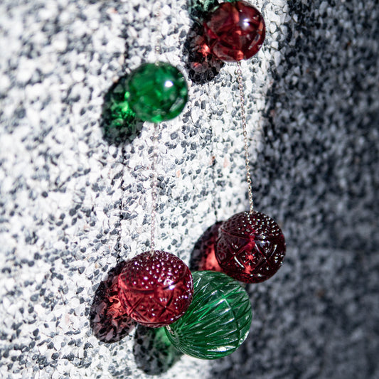 Close-up of brown and green glass beads on a textured surface