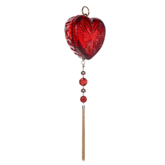 A red heart-shaped clutch bag with an embossed floral pattern, hanging from a gold-toned ring, with three decorative beads and a long gold tone tassel below, shown against a plain white background.