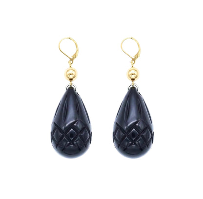 A pair of gold leverback drop earrings featuring carved teardrop-shaped black onyx pomegranate charms with a textured diamond pattern, set against a plain white background.