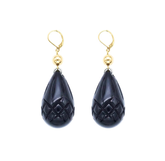 A pair of gold leverback drop earrings featuring carved teardrop-shaped black onyx pomegranate charms with a textured diamond pattern, set against a plain white background.
