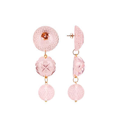 A pair of pink textured glass drop earrings with gold-tone hardware, featuring a round disc, a faceted oval, and a spherical bead on a plain white background.