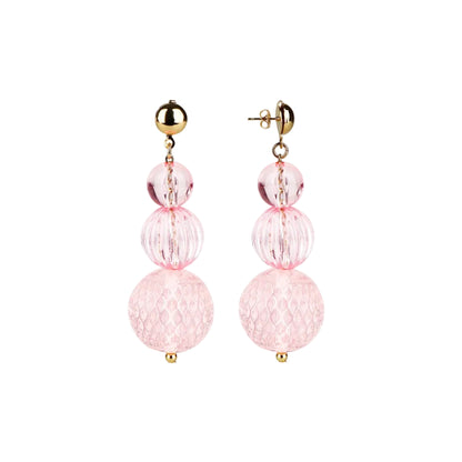 A pair of gold and light pink drop earrings with three stacked textured glass beads of varying sizes on a solid white background.