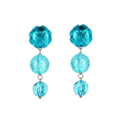 A pair of drop earrings featuring textured turquoise blue beads and faceted light blue circular discs, suspended from small gold-tone rings against a white background.