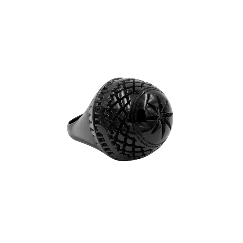 A black resin ring featuring a large, spherical, grenade-like textured centerpiece with a starburst motif on the front, set against a plain white background.
