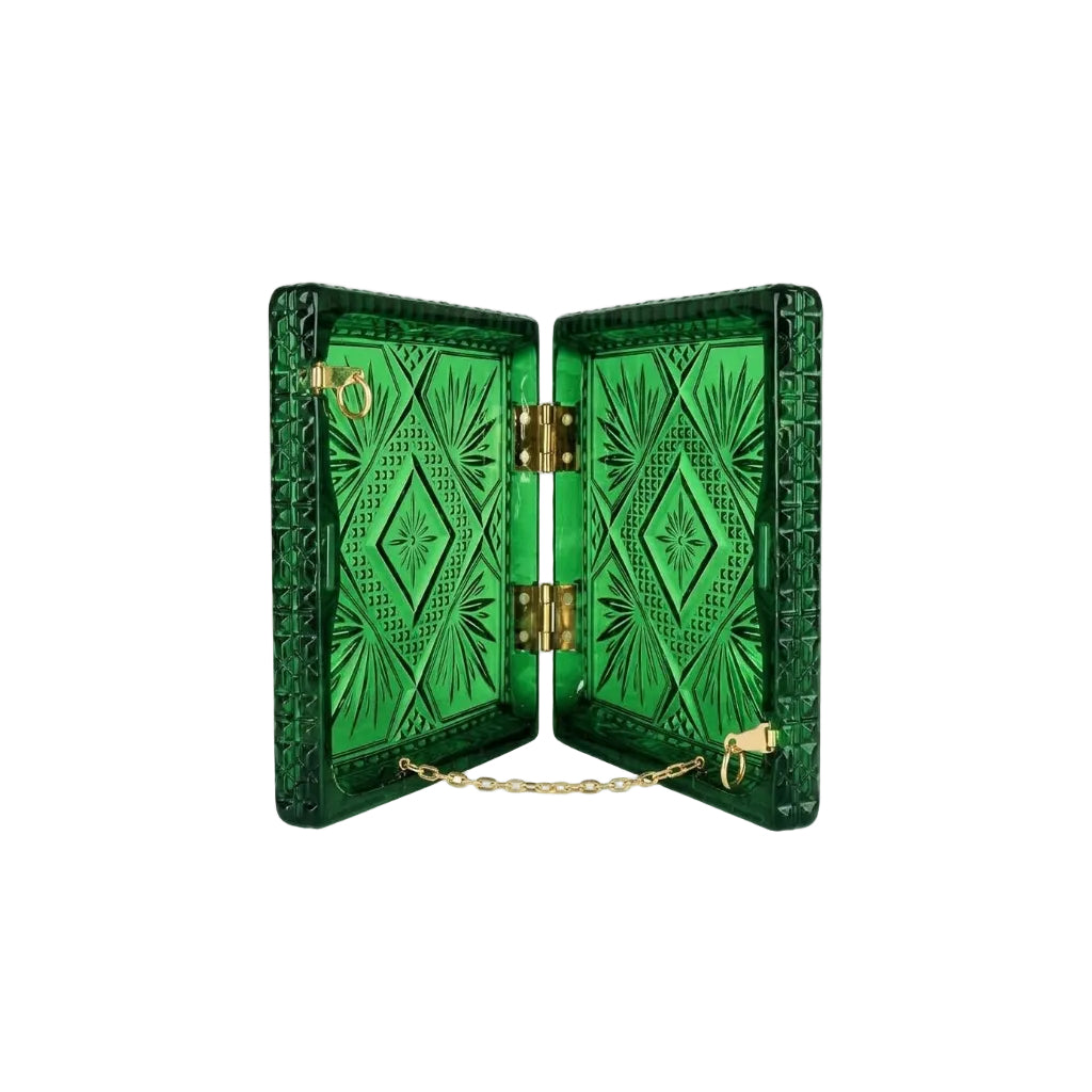 A green box cut glass inspired clutch with an open view, featuring geometric cut patterns on the front and back, gold-tone metal hinges, a small gold chain, and a ring clasp, shown on a plain white background.