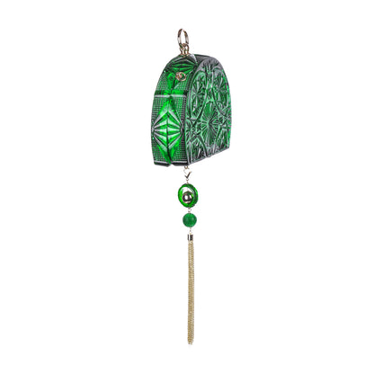 A green and gold carved clutch with a hanging tassel, displayed on a solid white background.